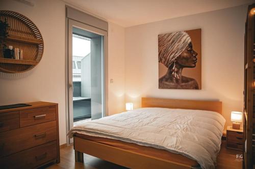 une chambre avec un lit avec un tableau sur le mur dans l'établissement Le Méribel - Conciergerie de la Yaute, à Sallanches