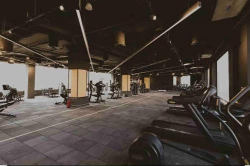 a gym with rows of treadmills and people exercising at Azha 2 bd chalet family only in Ain Sokhna