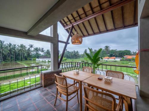 a dining room with a table and chairs and a balcony at Tarate Loft Studio Ubud in Ubud
