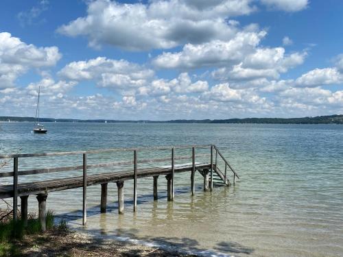 a dock on a body of water with a boat at Ferienwohnung Jardin im Kunsthaus in Greifenberg