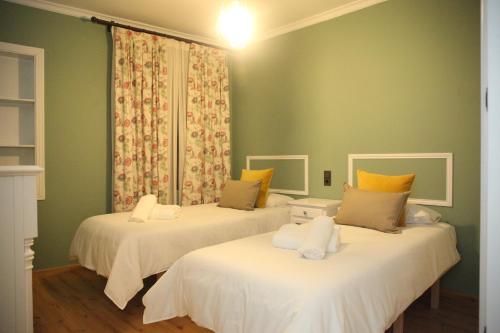 duas camas num quarto com paredes verdes em La Parada de Posadas em Posadas