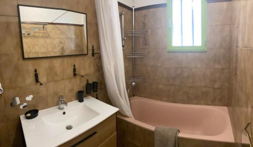 une salle de bain avec un lavabo et une baignoire et un lavabo dans l'établissement Maison avec Piscine privée + Clim proche de la mer, à Corneilla-del-Vercol