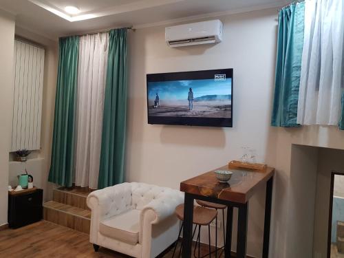 a living room with a television on a wall at IMPERIAL ROOMS - ULTRACENTRAL - jacuzzi cu hidromasaj in Oradea
