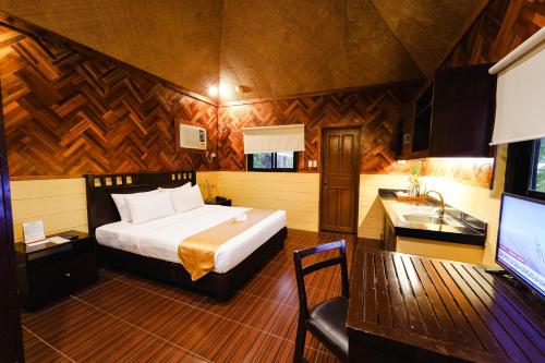a bedroom with a bed and a sink and a television at Sol Y Viento Mountain Hot Springs Resort in Calamba