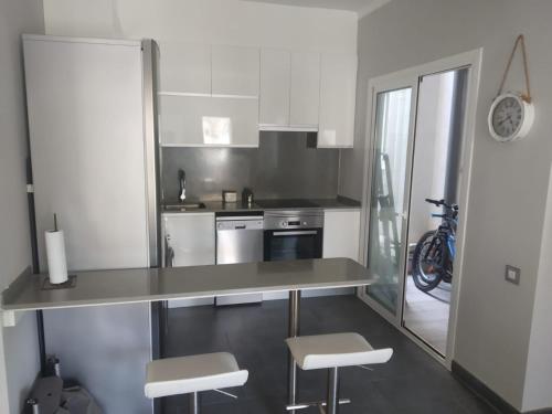 a kitchen with a counter and two stools in it at Baix a Mar in Torredembarra