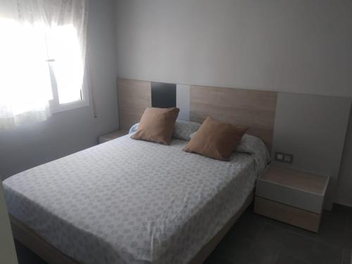 a bedroom with a bed with two pillows on it at Baix a Mar in Torredembarra