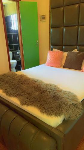 a bed with a brown furry blanket on it at Allooo Docteur in Douala
