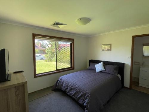 Schlafzimmer mit einem Bett und einem Fenster in der Unterkunft Lizzy’s on Lakeside in Lake Albert