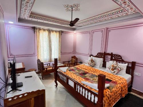 a bedroom with a bed and a desk and a television at Hotel Rime Vista in Jaipur