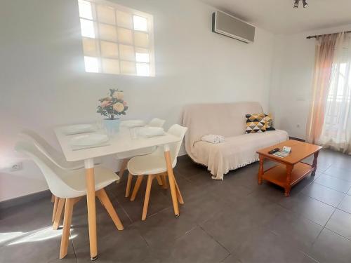 a living room with a white table and a couch at Apartamentos Las Arenas 3000 in Alcossebre