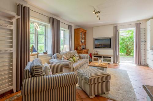 uma sala de estar com dois sofás e uma televisão em Annes Cottage 2 em Oevenum