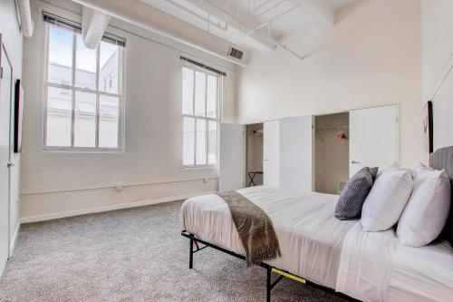 - une chambre blanche avec un grand lit et des fenêtres dans l'établissement TWO CozySuites Apartment with Skybridge Access #4, à Indianapolis