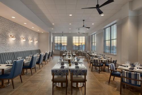 a dining room with tables and chairs and windows at Holiday Inn & Suites Ocean City by IHG in Ocean City