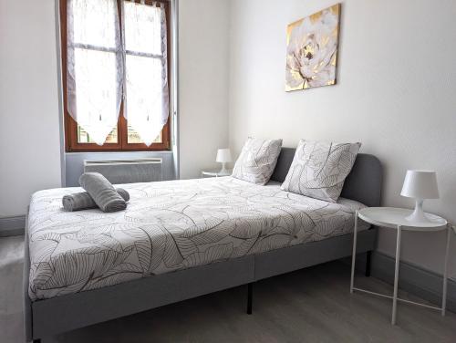 une chambre avec un lit, une table et une fenêtre dans l'établissement Le Mirage - appartement 2 chambres, salon, cuisine équipée, parking et wifi gratuit, à Mulhouse