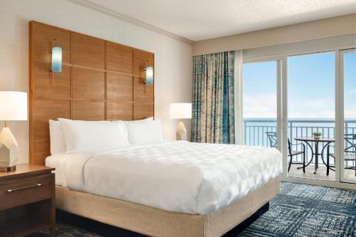 a hotel room with a bed and a balcony at Holiday Inn & Suites Ocean City by IHG in Ocean City