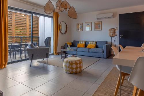 un salon avec un canapé bleu et une table dans l'établissement Les Terrasses de la Pinède - Appt climatisé, à Coti-Chiavari