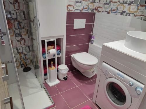 La salle de bains est pourvue de toilettes et d'un lave-linge. dans l'établissement Magnifique appartement 6 pers climatisé grande terrasse vue port, au Cap d'Agde