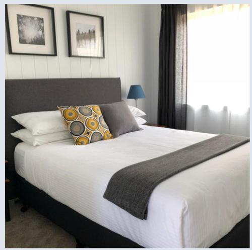 1 dormitorio con 1 cama blanca grande con almohadas en Appleyard Bed and Breakfast, en Forbes