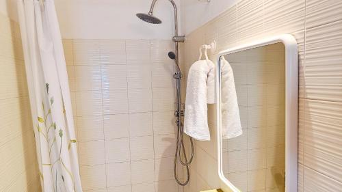 een badkamer met een douche en 2 witte handdoeken bij Casa Usignolo in Perugia