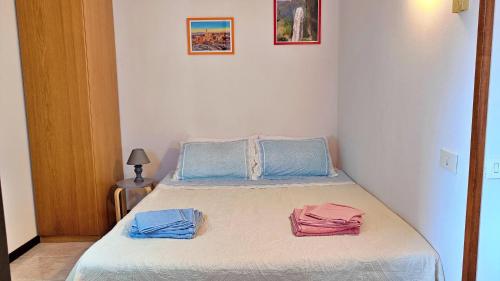 een slaapkamer met een bed met blauwe en roze handdoeken bij Casa Usignolo in Perugia