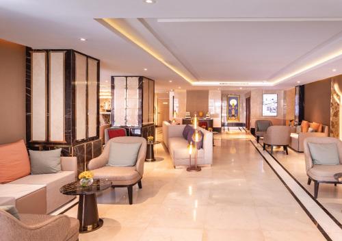 a lobby with couches and chairs in a building at SAMALA Hotel Bangkok in Bangkok