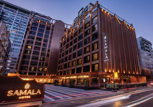 a building with a sign on the side of a street at SAMALA Hotel Bangkok in Bangkok