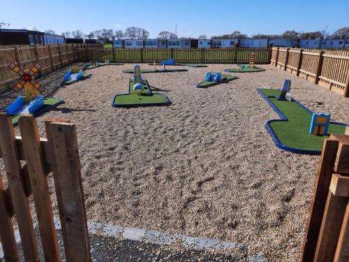 a playground with colorful play equipment in the sand at Cosy 2 Bed Chalet in Great Yarmouth