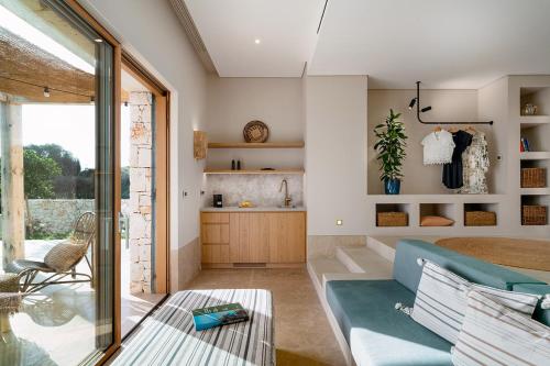 Eliamos Villas Hotel & Spa في سبارتيا: غرفة معيشة مع أريكة زرقاء وطاولة