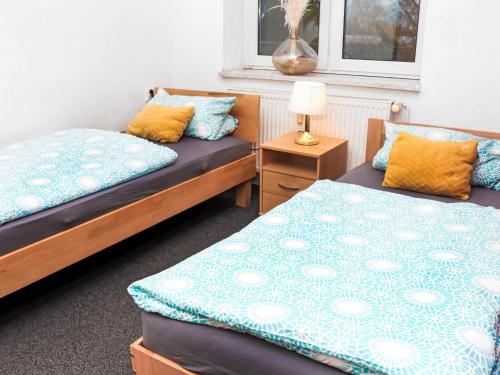 um quarto com 2 camas e uma mesa com um candeeiro em Rentarooms B em Oebisfelde
