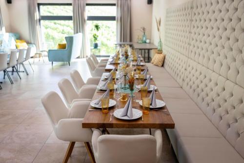 a long table in a restaurant with white chairs at Weingut Dietl in Riegersburg