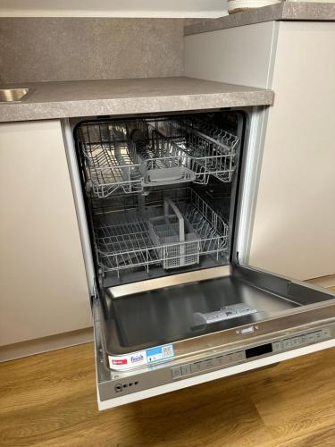 a dishwasher with its door open in a kitchen at Dümmerland Apartments in Lemförde
