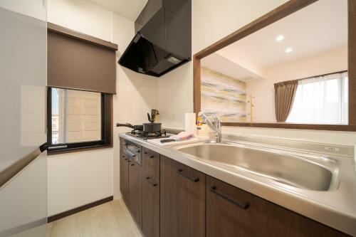 uma pequena cozinha com um lavatório e uma janela em Tabi no yado Hanakeshiki Momo 4th floor - Vacation STAY 42997v em Yufu