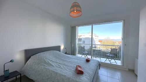 une chambre avec un lit et une grande fenêtre dans l'établissement Duplex-3 Chambres Giens-Wifi-Parking By HC, à Hyères