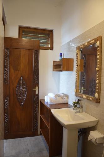 a bathroom with a sink and a mirror at Lui Ushongo Beach House in Pangani