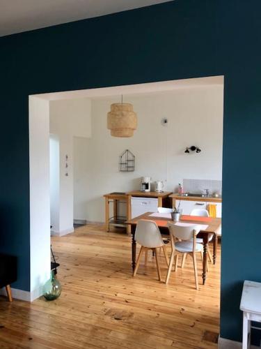 une cuisine et une salle à manger avec une table et des chaises dans l'établissement Maison de vacances, proche de la Baie de Somme, à Sailly-Flibeaucourt