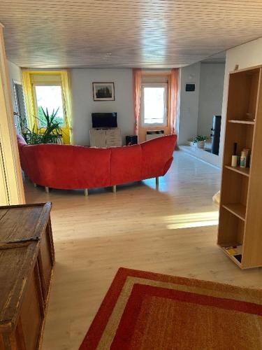 a living room with a large red couch in the middle at Appartamento sul lago in Gambarogno