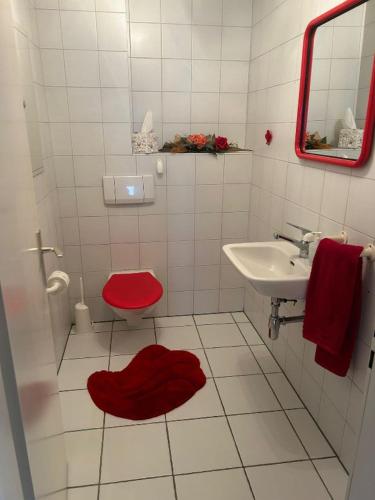 a bathroom with a red toilet and a sink at Appartamento sul lago in Gambarogno