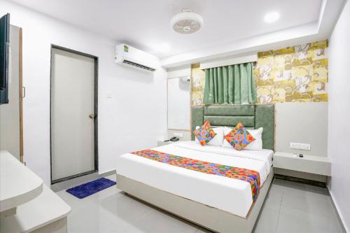 Habitación blanca con cama y espejo en FabHotel Grey Sky, en Gandhinagar
