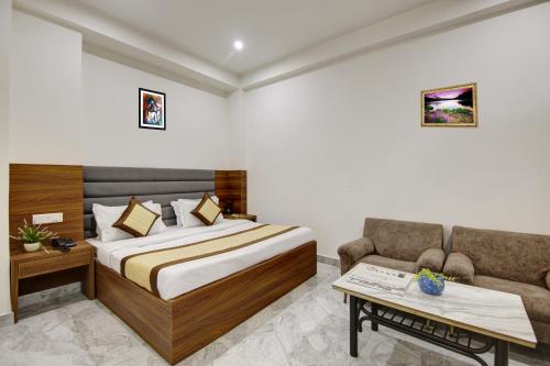 a hotel room with a bed and a couch at Hotel SB Grand Inn - Paharganj in New Delhi