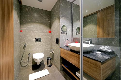een badkamer met een wastafel en een toilet bij Grand Vijayawada by GRT Hotels in Vijayawāda