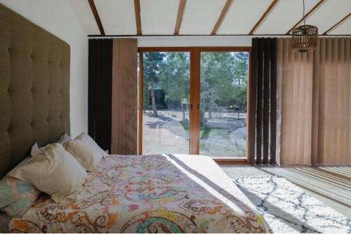 - une chambre avec un lit et une grande fenêtre dans l'établissement El Campirri, à Daimés