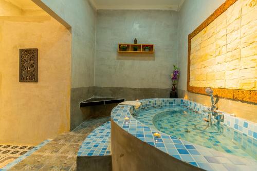 uma grande casa de banho com uma banheira com azulejos azuis em Angkor Rithy Boutiques em Siem Reap