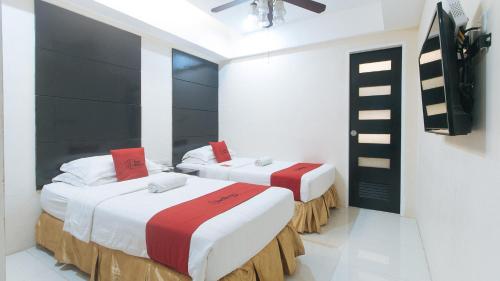 2 łóżka w pokoju z białymi ścianami w obiekcie RedDoorz at Grand Apartelle Hernan Cortes Cebu w Cebu