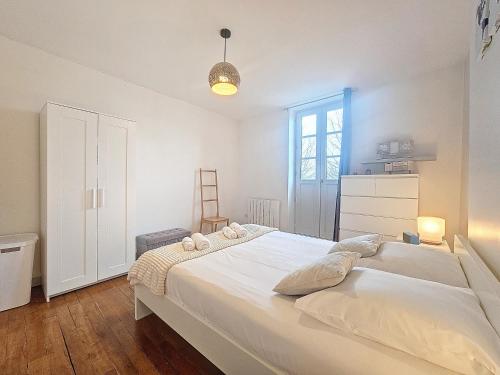 een slaapkamer met een groot wit bed in een kamer bij Le Régemortes, centre ville et proche du CNCS, avec services premium by PRIMO C0NCIERGERIE in Moulins