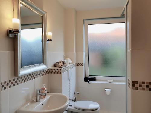 La salle de bains est pourvue d'un lavabo, de toilettes et de 2 fenêtres. dans l'établissement fewo1846 - Kranich - komfortable Wohnung mit 2 Schlafzimmern im Erdgeschoß, à Flensbourg