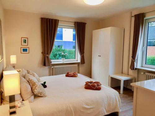 Un dormitorio con una cama con dos ositos de peluche. en fewo1846 - Kranich - komfortable Wohnung mit 2 Schlafzimmern im Erdgeschoß, en Flensburg