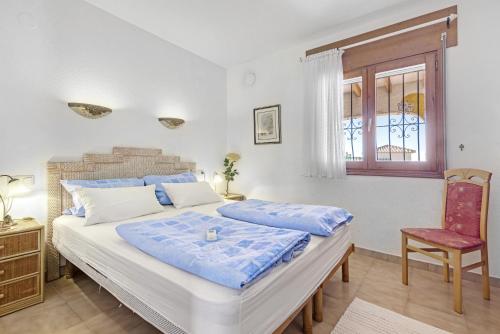 ein Schlafzimmer mit einem Bett, einem Stuhl und einem Fenster in der Unterkunft Casasilma in Cumbre del Sol