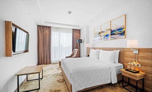 a hotel room with a white bed and a window at Grand Vijayawada by GRT Hotels in Vijayawāda