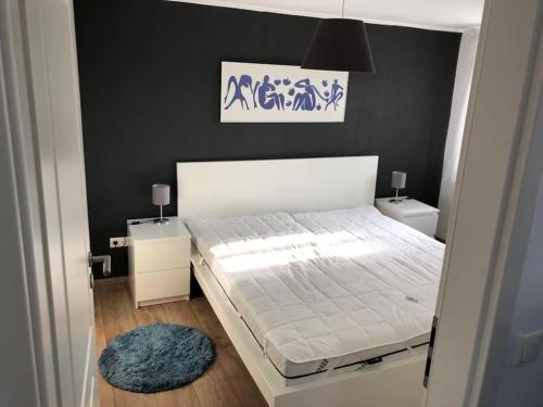 a bedroom with a white bed and a black wall at Gemütliche Kleine Wohnung in Wendelstein