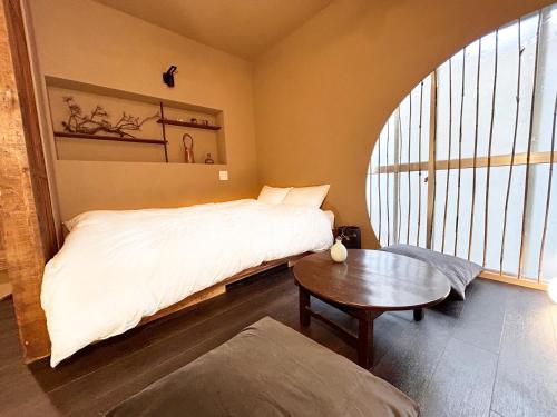 sypialnia z białym łóżkiem i stołem w obiekcie 満竹華庵 manchikan w Tokio